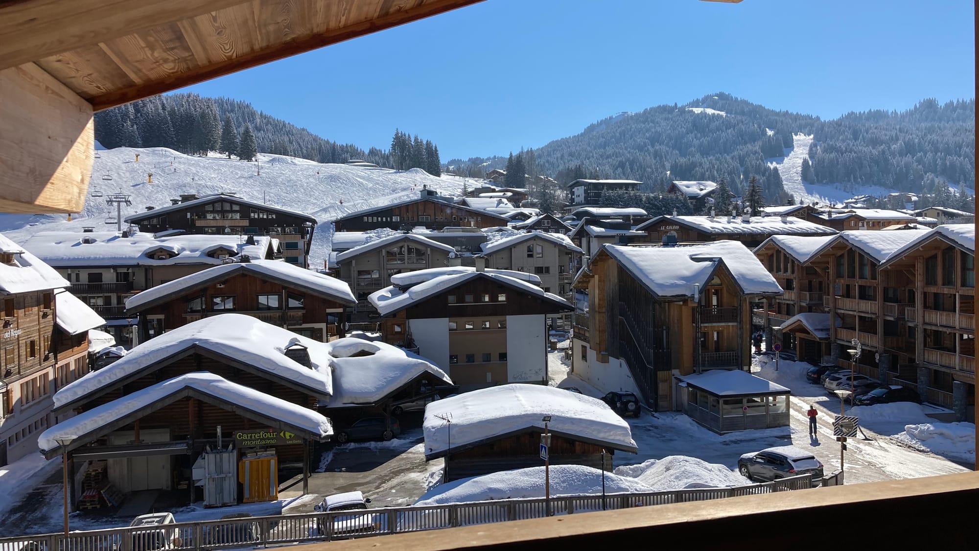 Balcony with view on snowy village and ski slopes