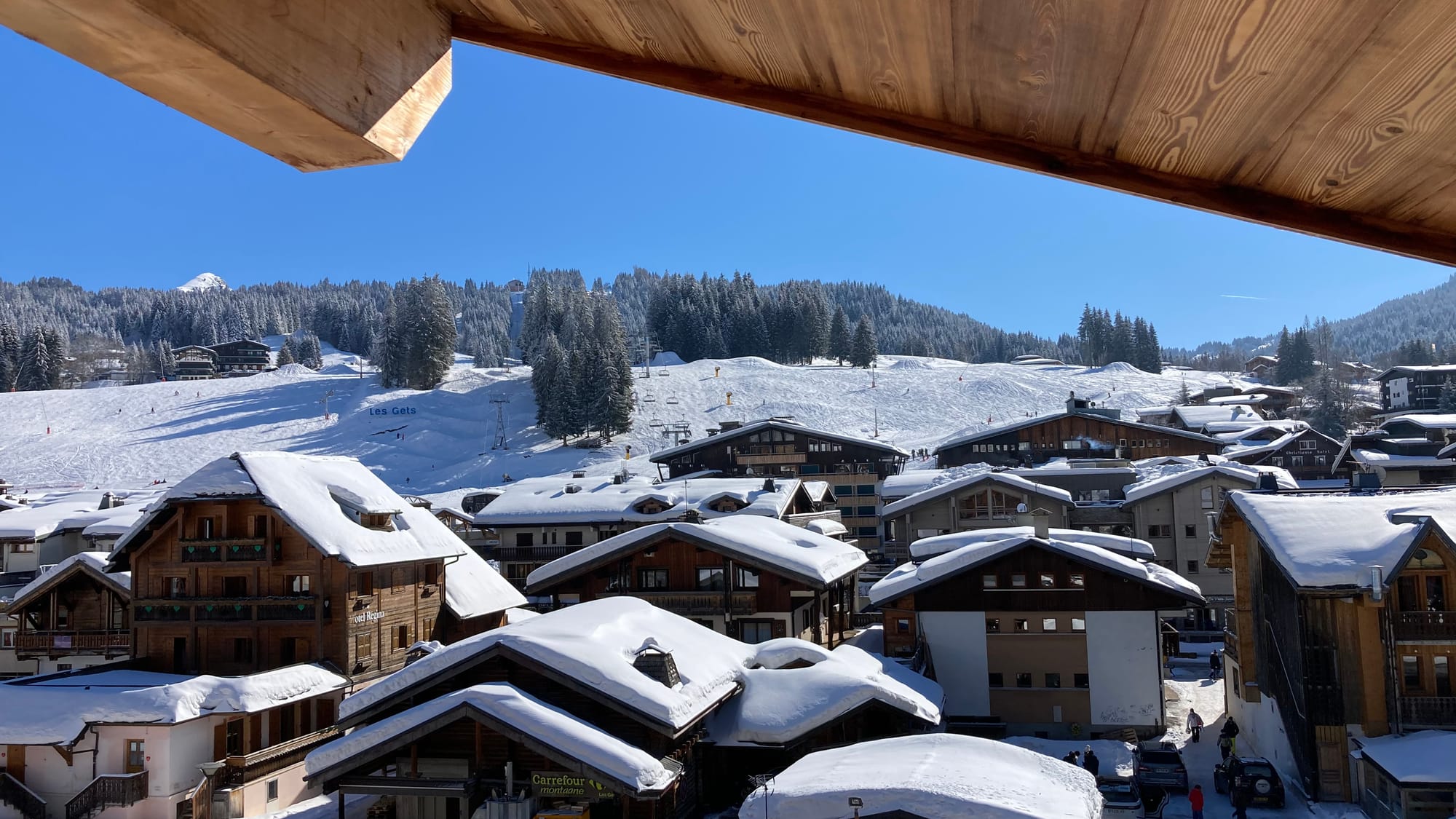 Balcony with view on snowy village and ski slopes