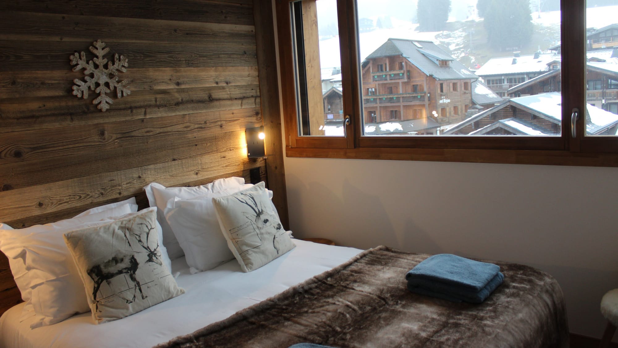 Master bedroom with view on snowy village and ski slopes